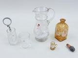 a glass pitcher, a glass cup, a glass bottle, and a lighter