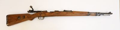 un vieux fusil en bois accroché au mur d'une pièce
