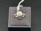 gros plan d'une bague en argent sur une surface noire