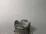 a small silver object sitting on a table next to a smaller silver object