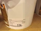 a white bucket with a label on it sitting on the floor