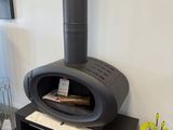 a black stove sitting in the corner of a living room