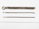 a group of silver chains on a white surface