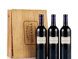 three bottles of wine in front of a wooden box