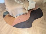 un tapis rond posé à même le sol, recouvert d'une couverture