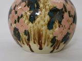 a small vase that has a tag on the top of it
