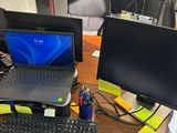 un bureau sur lequel se trouvent un ordinateur portable, un écran, un clavier, une souris et d'autres objets