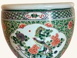 a green and white bowl with a bird and flowers on it