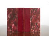 two books sitting on a table with a red cover