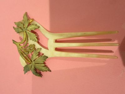 une fourchette sur laquelle est posée une plante, posée sur une surface rose