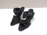black leather sandals with braid straps on a white surface