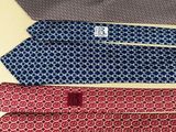 four ties are laid out on a table with a tag on them