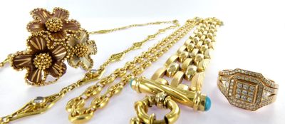 a lot of gold jewelry on a white surface