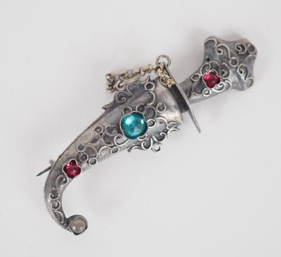 un poignard en argent orné d'une pierre bleue et rouge