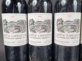 three bottles of red wine are lined up on a table