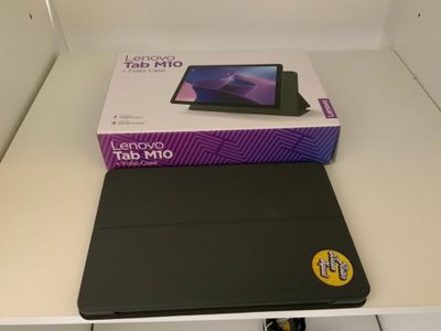 un ordinateur portable posé sur une table, sur laquelle se trouve une boîte