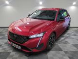 une voiture rouge garée dans un garage au sol en damier