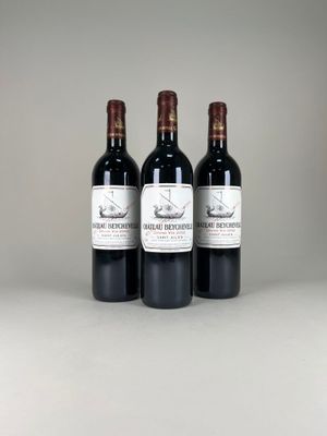 trois bouteilles de vin posées sur une table blanche