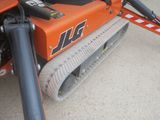 a small orange tractor that is parked in the dirt