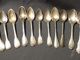 six silver spoons are lined up in a row on a table