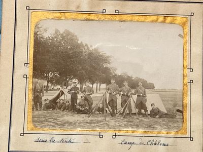 an old photo of a group of people sitting in a field