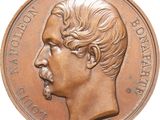 une image montrant un gros plan d'une médaille de bronze représentant le visage d'un homme