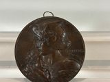 an old bronze medal with a dog on it sitting on a table