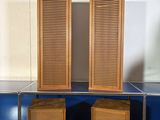 two wooden shutters on top of a blue shelf