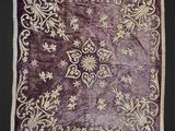 un gros plan sur un tapis violet et doré sur fond noir
