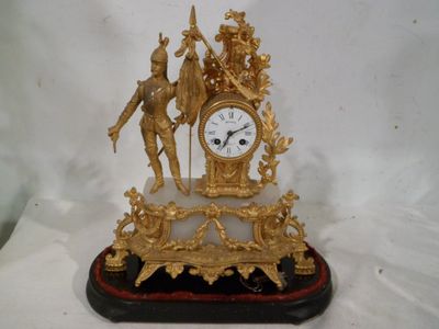 une horloge en or avec une statue d'un homme et d'une femme dessus