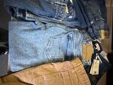 several pairs of jeans stacked on top of each other in a box