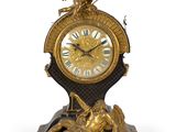 une horloge surmontée d'une statue représentant un homme