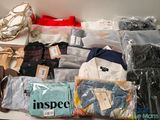 de nombreux types de vêtements et de sacs posés sur une table