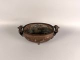 an old metal bowl sitting on top of a white surface