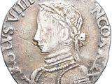 a silver coin with an image of a man wearing a hat