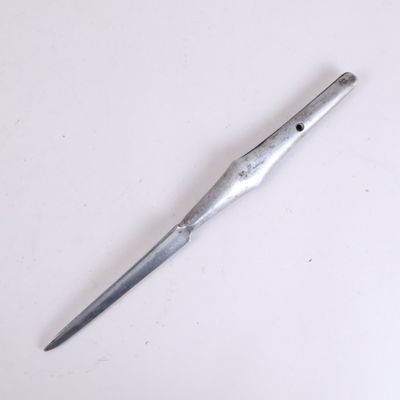 un petit couteau posé sur une surface blanche