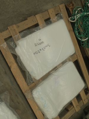 une palette de papier toilette blanc posée à côté d'une pile d'autres rouleaux de papier toilette