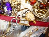 un tas de bijoux posés sur une table, avec une ceinture rouge