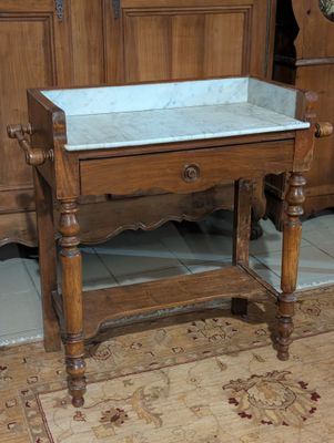 une table en bois avec un plateau en marbre dans une pièce