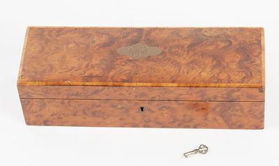 an old wooden box with a key in it on a white surface