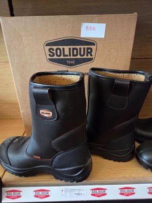 two pairs of black boots are on a shelf in a store
