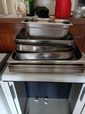 Dans une cuisine, plusieurs casseroles sont empilées les unes sur les autres