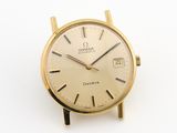 une montre en or sur une surface blanche avec un fond blanc