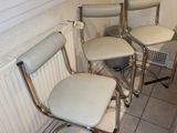 four chairs in the corner of a room with tile flooring