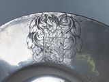 a silver plate with a design on it