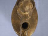 a gold vase that is sitting on a white surface