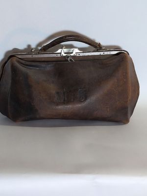 un porte-monnaie en cuir marron posé sur une table blanche