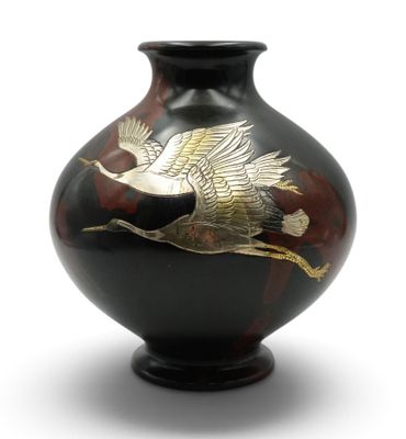 un vase sur lequel est peint un oiseau sur fond blanc