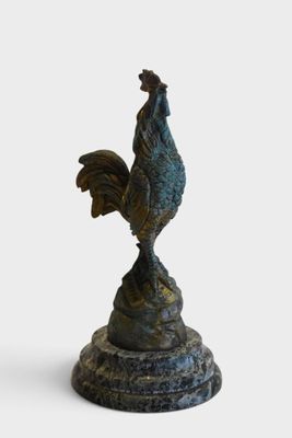 statue of a rooster on a pedestal on a white background
