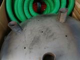 a large metal tank with a green hose in it